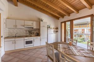 a kitchen with white cabinets and a table and a dining room at Apt Gardasee Lazise Colá in Colà di Lazise