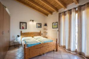 a bedroom with a wooden bed and a window at Apt Gardasee Lazise Colá in Colà di Lazise