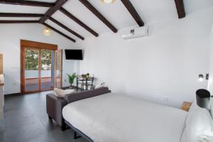 a bedroom with a bed and a couch and a tv at Casa Celestina in Temisas +21 photos