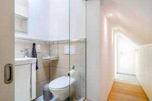 a bathroom with a toilet and a glass shower door at Kleines Zimmer am See in Bodman-Ludwigshafen