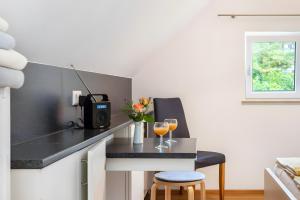a kitchen with a table with two glasses of wine at Kleines Zimmer am See in Bodman-Ludwigshafen