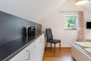 a bedroom with a black counter top and a chair at Kleines Zimmer am See in Bodman-Ludwigshafen +8 photos
