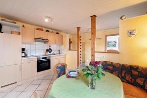 a kitchen with a table with a vase of flowers on it at Ferienwohnung Heike Schreiber in Sasbachwalden