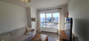 a living room with a couch and a large window at Apartamento La Palma Corralejo in Corralejo