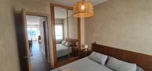 a bedroom with a mirror and a bed and a lamp at Apartamento La Palma Corralejo in Corralejo