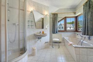 a bathroom with a tub and a sink and a bath tub at Pension Bergblick in Marienberg +126 photos