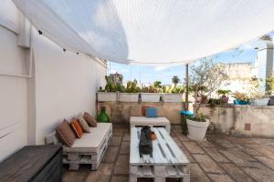 a patio with two benches and a white canopy at La Cartapesta in Lecce