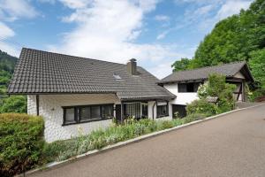 a white house with a black roof on a road at Ferienwohnung Am Lehen Schiltach in Schiltach