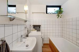 a white bathroom with a sink and a tub and a toilet at Ferienwohnung Am Lehen Schiltach in Schiltach