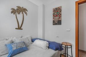 a bedroom with a bed with blue and white pillows at Estudio Rebe in Tazacorte