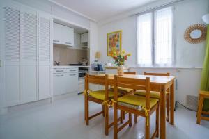 a kitchen with a wooden table and chairs in a room at Logis Helena in Elne