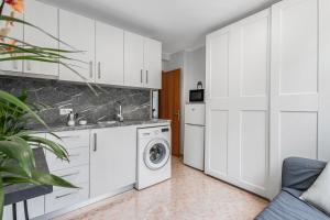 a kitchen with white cabinets and a washing machine at Estudio Rebe in Tazacorte +12 photos