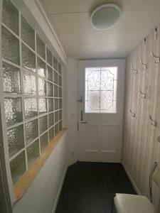 a hallway with a white door and a window at Logis Helena in Elne