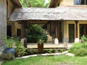 a dog sitting in front of a house at Villa Layangan - Two Bedrooms with Pool Access in Sanur