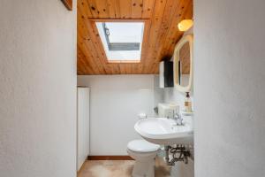 a bathroom with a toilet and a sink and a skylight at Casa Mary in Prataccio