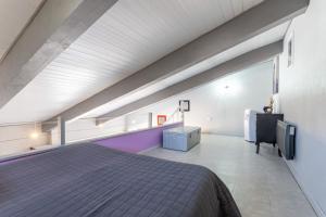 a attic bedroom with a bed and a balcony at Logis Du Conflent in Rodès