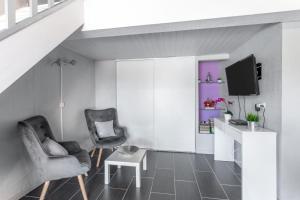 a living room with two chairs and a tv at Logis Du Conflent in Rodès