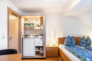 a small bedroom with a bed and a sink at Haus Edith in Gersfeld