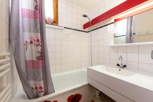 a white bathroom with a sink and a bath tub at La Bûche in Valmorel +15 photos