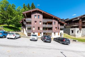 a group of cars parked in front of a building at La Bûche in Valmorel
