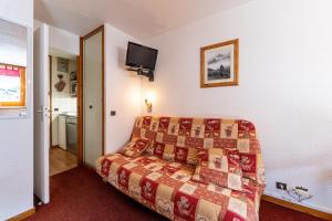 a hotel room with a bed and a tv on the wall at La Bûche in Valmorel