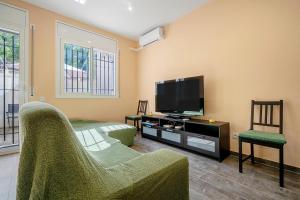 a living room with a flat screen tv and a couch at Casa Lluma in Aldover