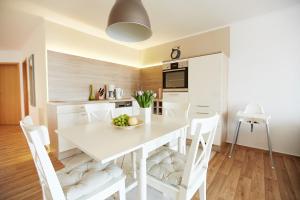 a kitchen and dining room with a white table and chairs at Haus Strandeck Nordstrand 18 in Göhren +3 photos