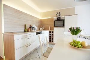 a kitchen with white cabinets and a table with a bowl of fruit at Haus Strandeck Nordstrand 18 in Göhren