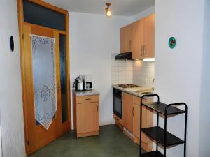 a small kitchen with a stove and a door at Kuryhof in Simonswald