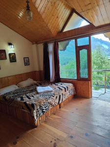 a bedroom with a bed in a room with a large window at Hikers & Bikers in Haripūr