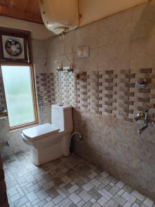a bathroom with a toilet and a window at Hikers & Bikers in Haripūr +61 photos