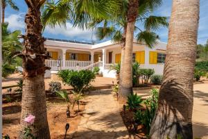 a house with palm trees in front of it at Villa Can Andreuet de Baix in Illes Balears
