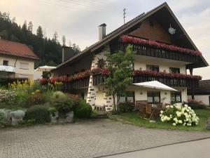 a house with flowers on the side of it at Haus Hubertus in Enzklösterle