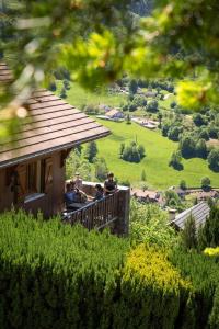 a group of people sitting on a balcony of a house at Chalet Bellevue Vue exceptionnelle in Basse-sur-le-Rupt