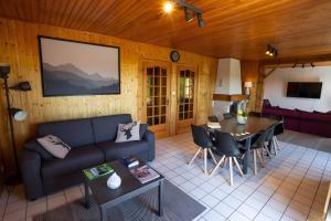 a living room with a couch and a table at Chalet Bellevue Vue exceptionnelle in Basse-sur-le-Rupt