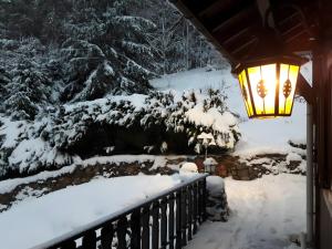 a light on a porch in the snow at Chalet Bellevue Vue exceptionnelle in Basse-sur-le-Rupt +11 photos