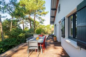 a patio with a table and chairs on a balcony at Villa proche du lac d'Hossegor in Soorts-Hossegor