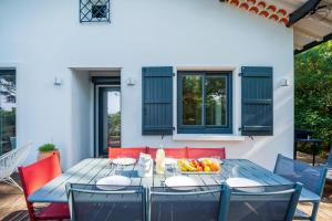 a dining table with a bowl of fruit on it at Villa proche du lac d'Hossegor in Soorts-Hossegor