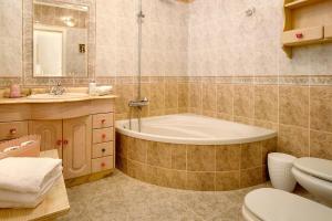 a bathroom with a tub and a toilet and a sink at Holiday Home Hemi in Valsequillo +20 photos