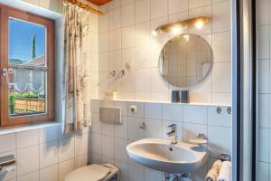 a bathroom with a sink and a toilet and a mirror at Ferienhaus St Christoph in Mittenwald +65 photos