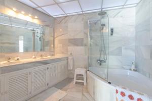 a bathroom with a tub and a sink and a shower at Deluxe Apartment with Jacuzzi in Marbella +17 photos