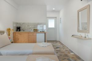 a white room with a bed and a kitchen at Niki's Studios Kalymnos in Kalymnos +125 photos