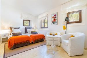 a white bedroom with a bed and a chair at Finca Son Pol in Andratx