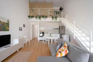 a living room with a gray couch and a staircase at Dimora Adriatica in Bari