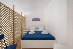 a bedroom with a bed with a blue blanket at Dimora Adriatica in Bari