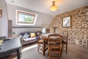 a living room with a table and a brick wall at Gîtes Ker Mané in Erdeven