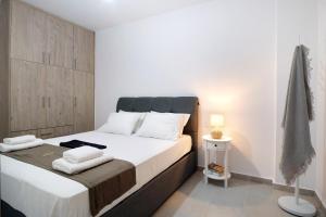een slaapkamer met een groot bed met witte lakens en handdoeken bij Oceanida Sofia Luxury Suite in Nikiana