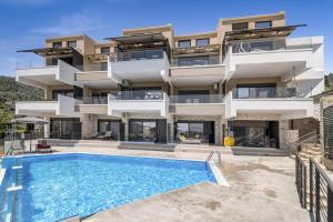een appartementencomplex met een zwembad ervoor bij Oceanida Sofia Luxury Suite in Nikiana +15 foto's