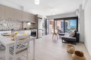 een keuken en woonkamer met een tafel en stoelen bij Oceanida Sofia Luxury Suite in Nikiana