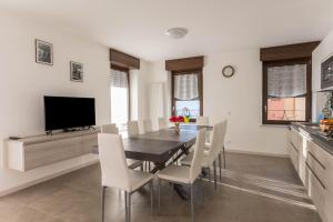 a dining room with a table and white chairs at Casa Balansina Lake View in Brenzone sul Garda